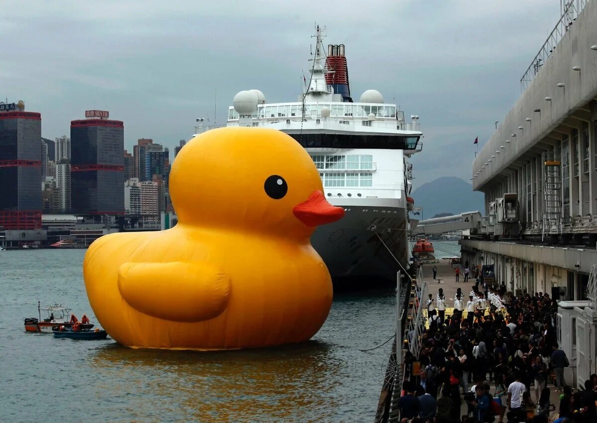 A photo of a giant duck with a ship in the back